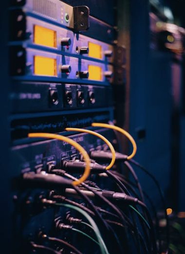 Close-up of network cables and ports in a server rack, showcasing connectivity.